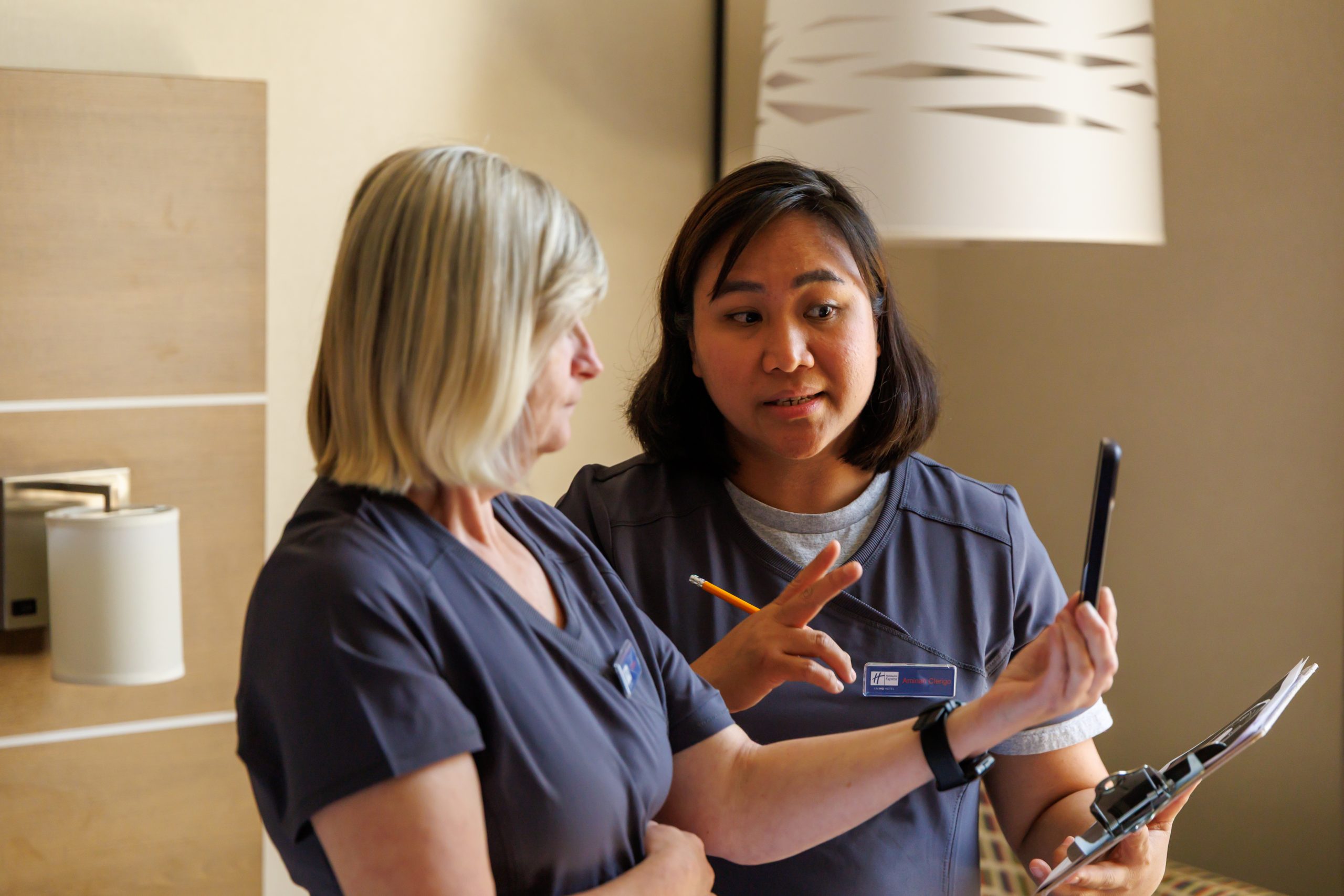 A staff member and Deaf client communicate using a tablet displaying a live ASL-English interpreter through Access ASL.