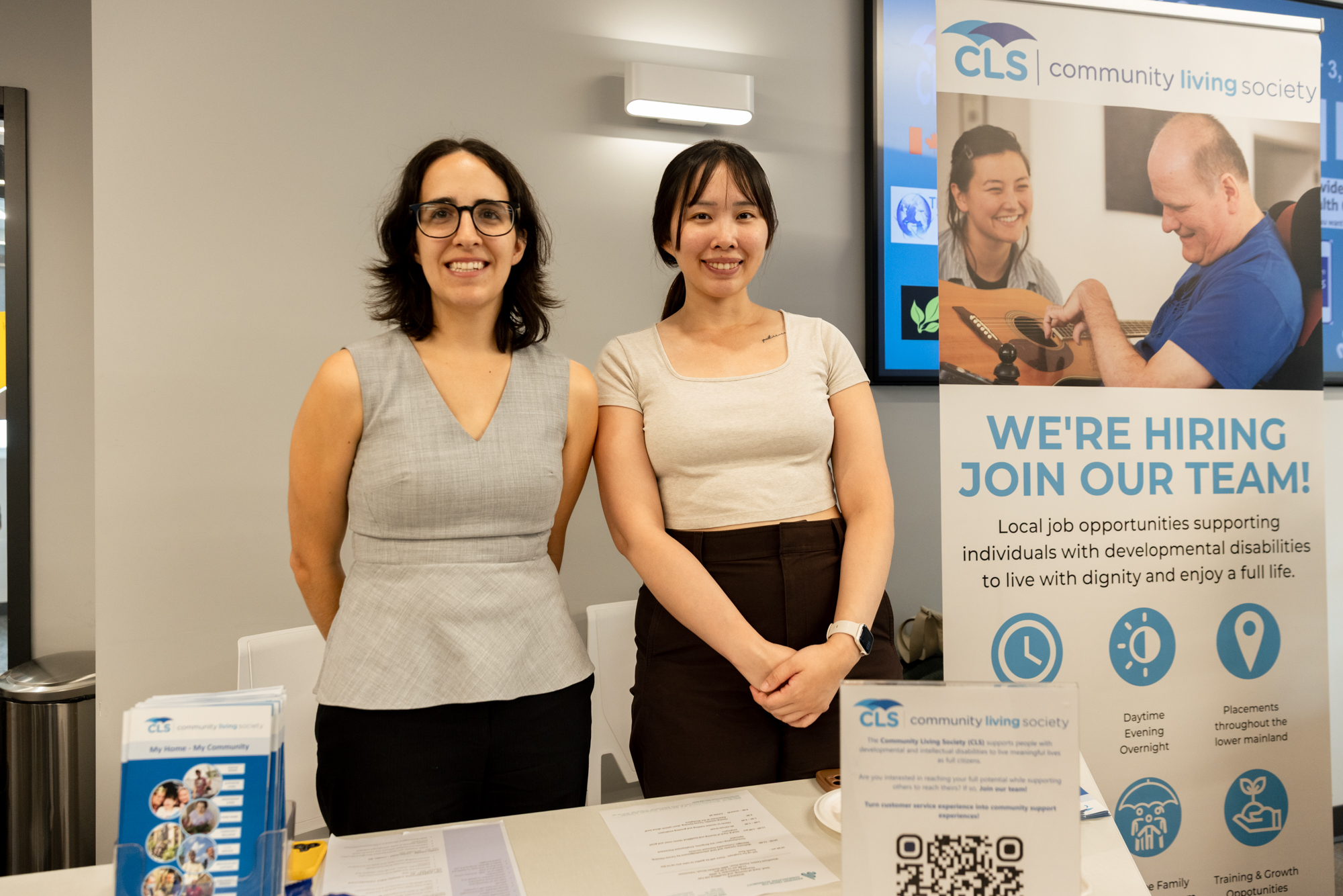 Two Community Living Society representatives smile behind their recruitment table at Wavefront Centre’s 2026 Job Fair.